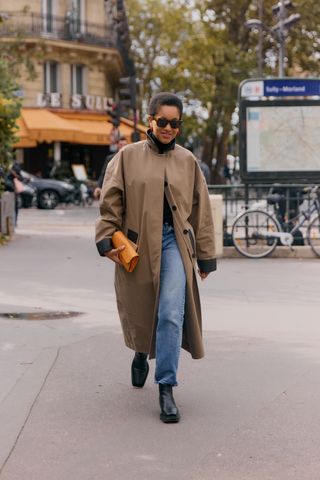 Showgoer at Paris Fashion Week wearing funnel neck coat.