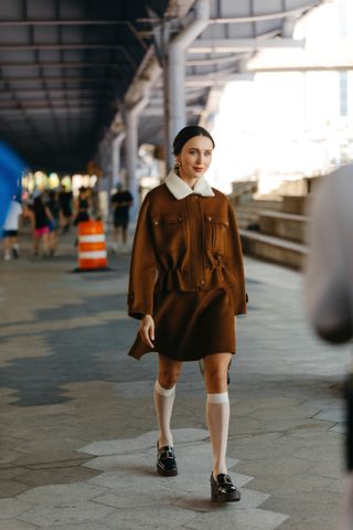 Woman at Fashion Week walking in the street wearing loafers,