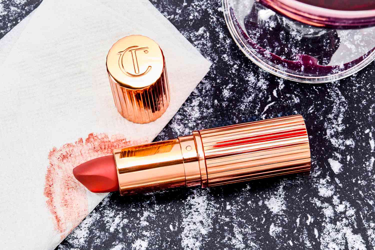 A close up of the Charlotte Tilbury lipstick head and lipstick smear on a napkin