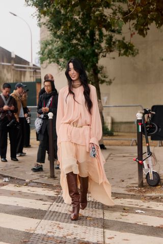 Fashion showgoer wearing bohemian dress at Paris Fashion Week.