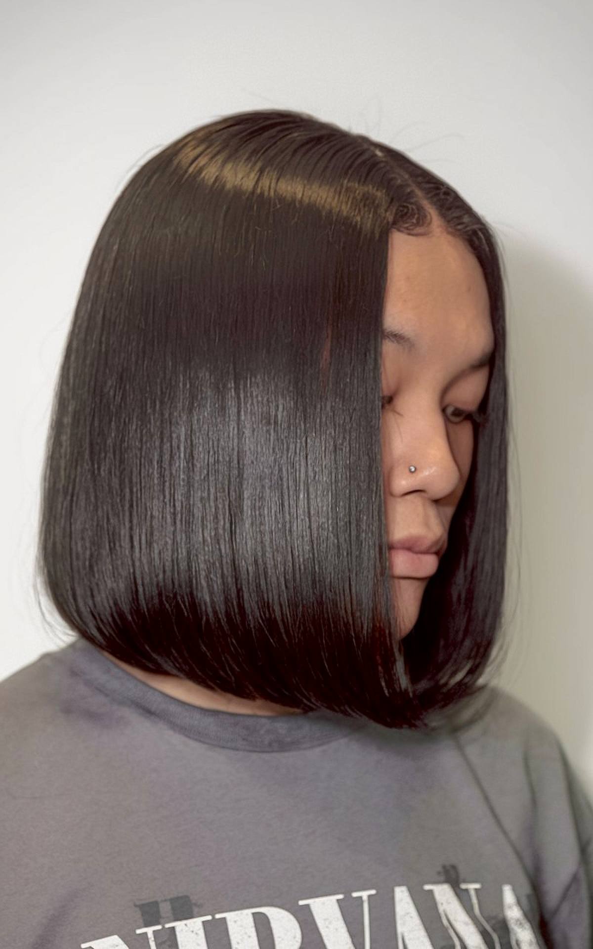 Side part silk press for bob hairstyle with sleek asymmetrical cut