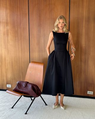 Elsa Hosk wearing a black midi dress and Bottega Veneta Lauren 1980 clutch