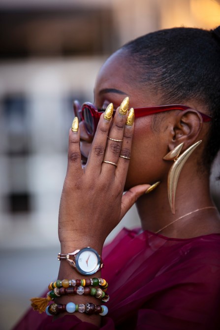 A fashion week guest with gold 3D nail art.