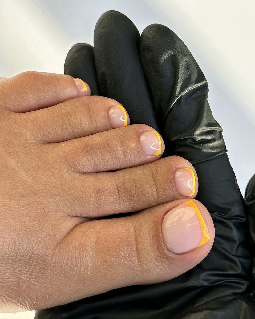 Try an orange French tip pedicure for Sagittarius season 2024.