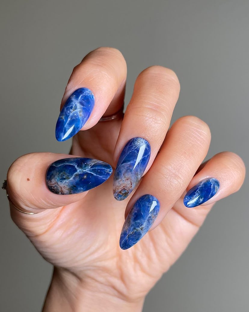 Try blue gemstone nail art for Sagittarius season 2024.