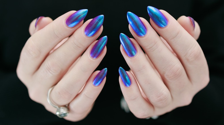 A woman's hands with blue chrome nails.