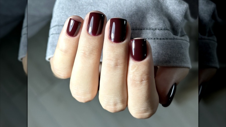 An off-black manicure in shades of dark cherry.