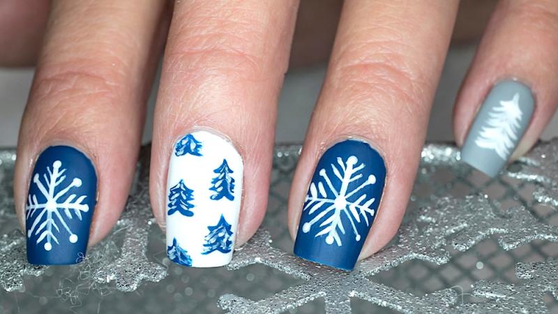 winter themed holiday nails in blue, silver, and white