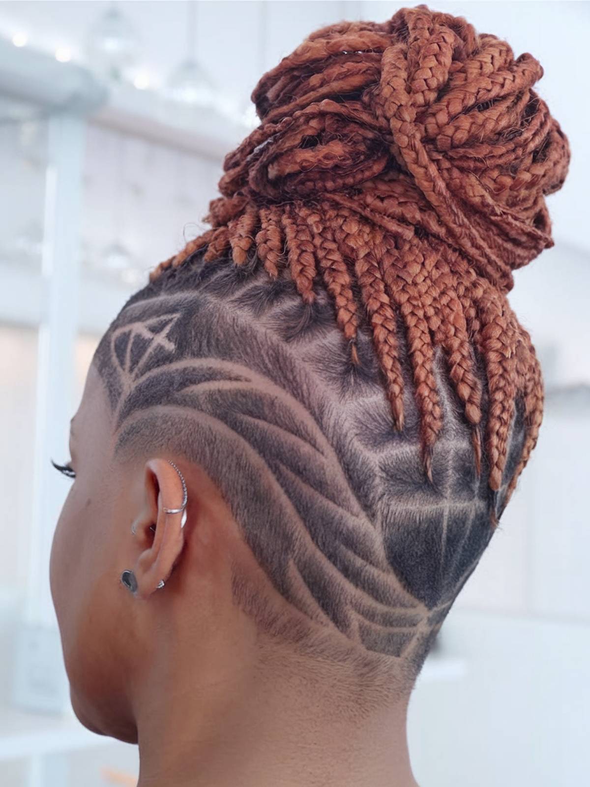 Box braids with high bun and shaved undercut patterns