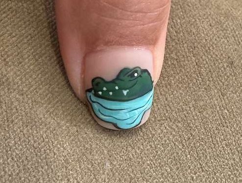 a fingernail with art of an alligator on it