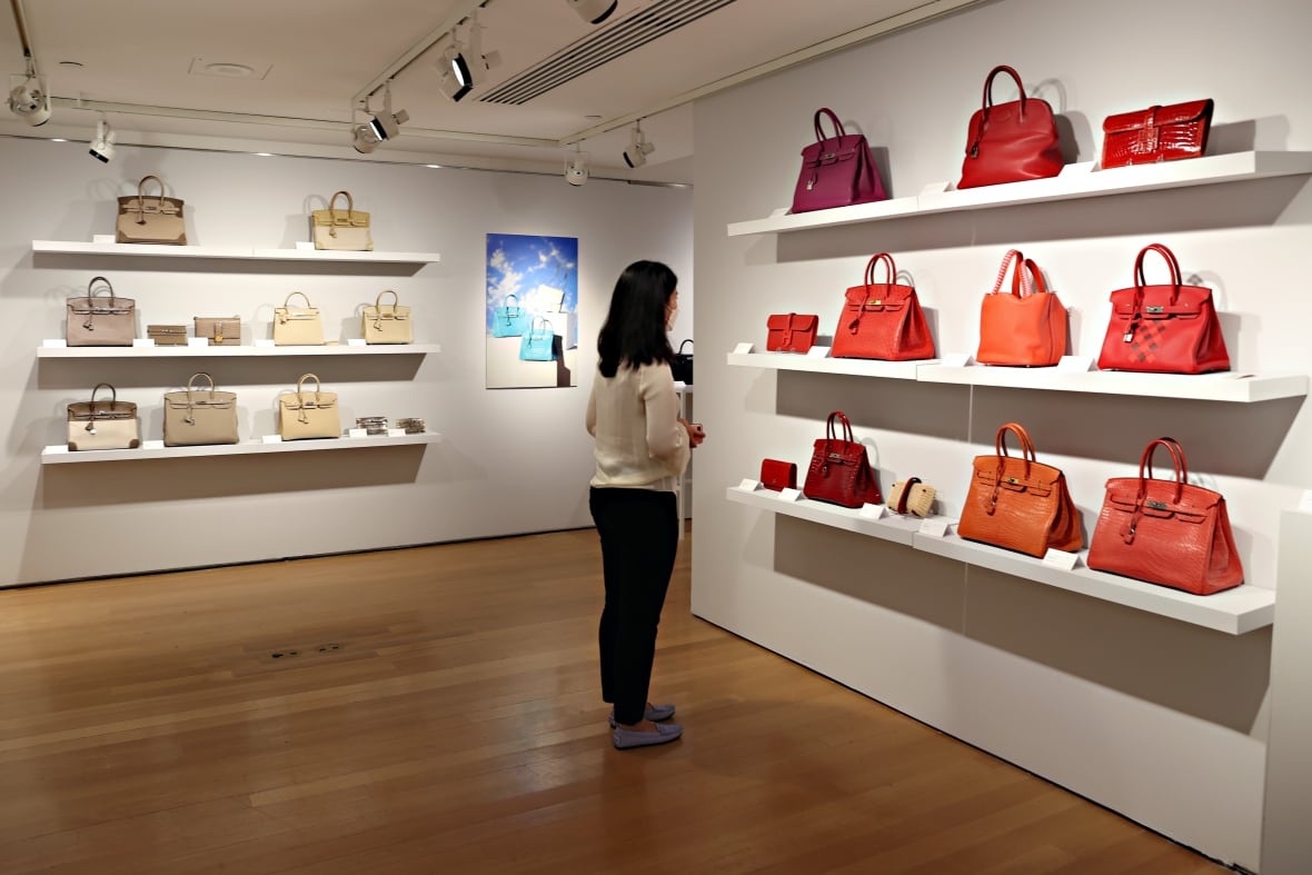 A woman looks at a display of handbags