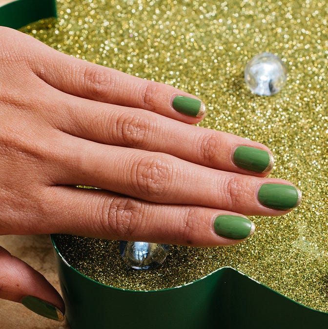 st patricks day nail ideas green gold tips a hand with painted fingernails in green polish with gold tips