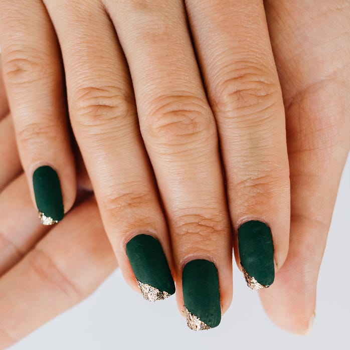 st patrick day nail ideas green gold angle tips a hand with painted fingernails in dark green with an angled gold glittery tip on the nails