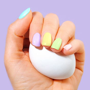 elegant womans hand with pastel color manicure holding a white egg easter holiday composition stylish trendy manicure trendy color of the year 2022 very peri purple violet lavender color background luxurious background design front view copy space close up
